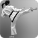 Image of a woman with ponytail doing a side kick with view from back.