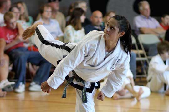 A woman executes a back kick during a hyung.