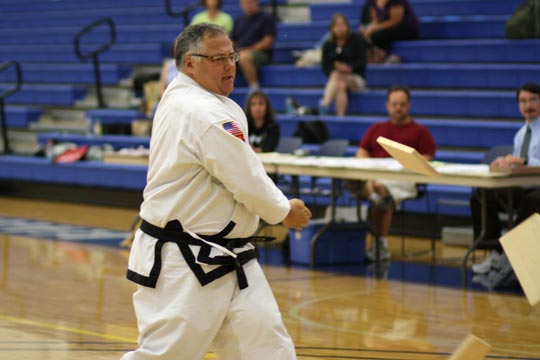 A black belt breaks two self-suspended boards with an inward knifehand.