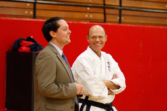 The tournament director (Will Coulter) and Mr. Bailey watch from the sidelines.